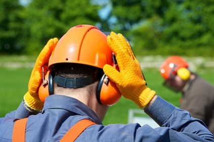 Bûcheron avec casque et gants de protection