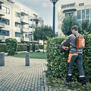 Taille-haie à batterie Husqvarna en cours d'utilisation